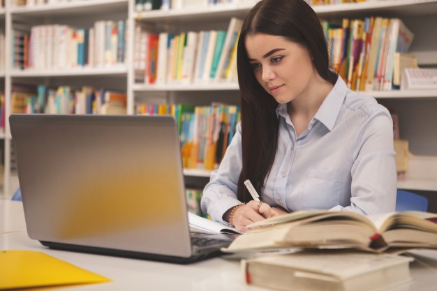 lovely-female-student-working-laptop-library_118628-271